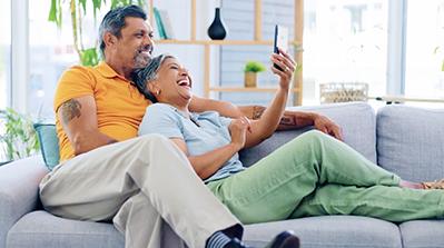 Couple on couch looking at their phone.