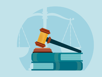 A gavel on books with a scale in the background.