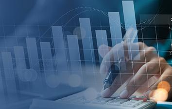 Hand using a calculator overlaid with upward-trending bar and line charts, representing financial growth and data analysis.